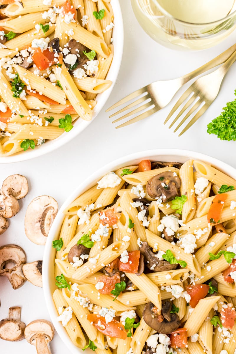 bowls of penne with mushrooms tomato and gorgonzola cheese