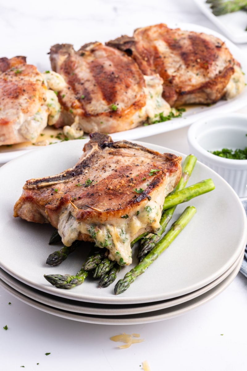 pork chops stuffed with smoked gouda displayed on plate with asparagus