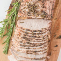 rosemary pork roast sliced on wood board