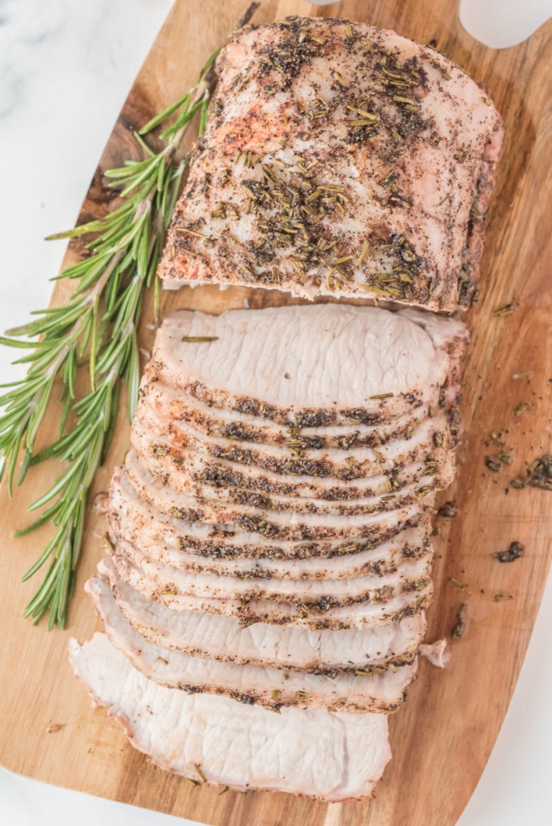 rosemary pork roast sliced on wood board