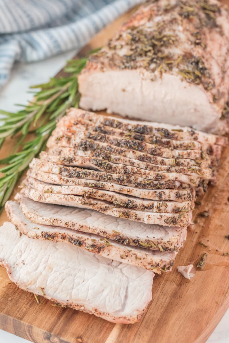 sliced rosemary pork roast on a cutting board