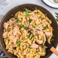 salmon fusilli in a skillet with spoon