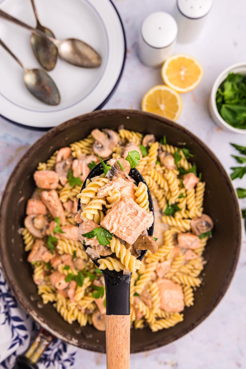 spoonful of salmon fusilli above skillet of the rest of the pasta dish