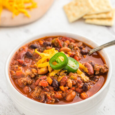 bowl of chili with cheese and jalapeno on top