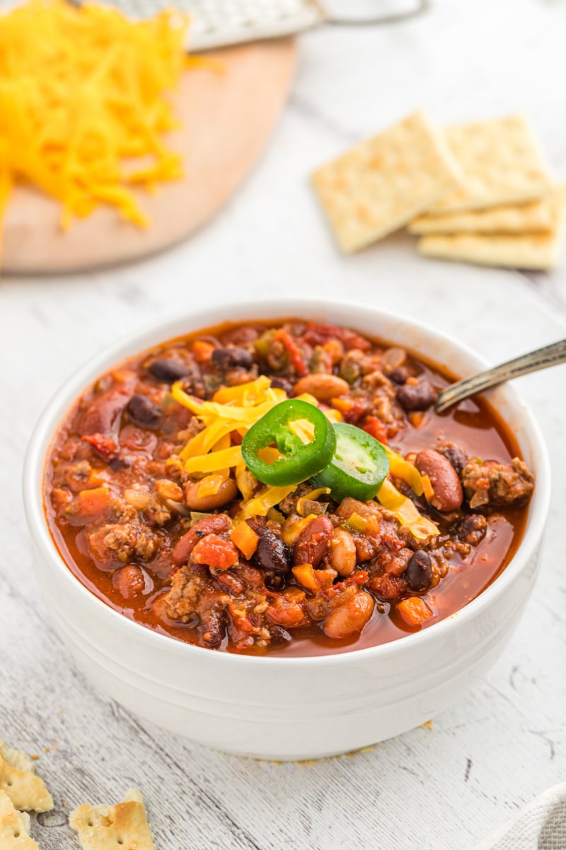 Three Bean and Beef Chili recipe from RecipeGirl.com #threebean #3bean #bean #beef #chili #recipe #RecipeGirl bowl of chili with cheese and jalapeno on top