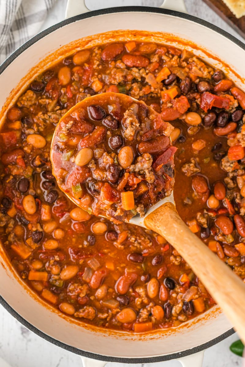 Three Bean and Beef Chili recipe from RecipeGirl.com #threebean #3bean #bean #beef #chili #recipe #RecipeGirl pot of chili with wooden spoon taking some out