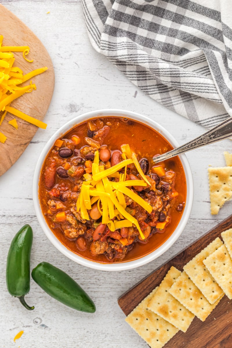 Three Bean and Beef Chili recipe from RecipeGirl.com #threebean #3bean #bean #beef #chili #recipe #RecipeGirl bowl of three bean and beef chili with cheese on top