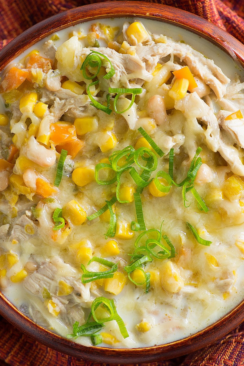 overhead shot of Bowl of White Chicken Chili in a rust colored bowl with similar colored napkin