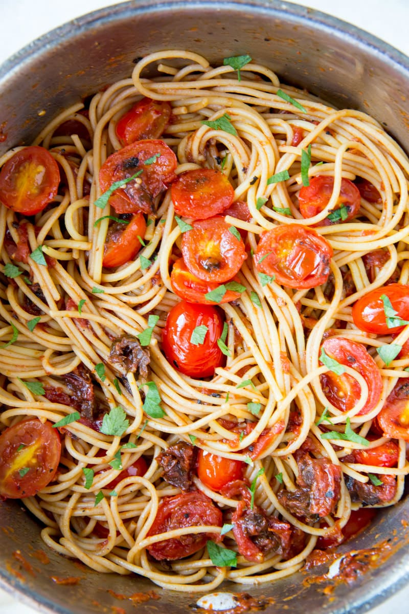 overhead shot of spaghetti with three tomato sauce in a stainless steel pot