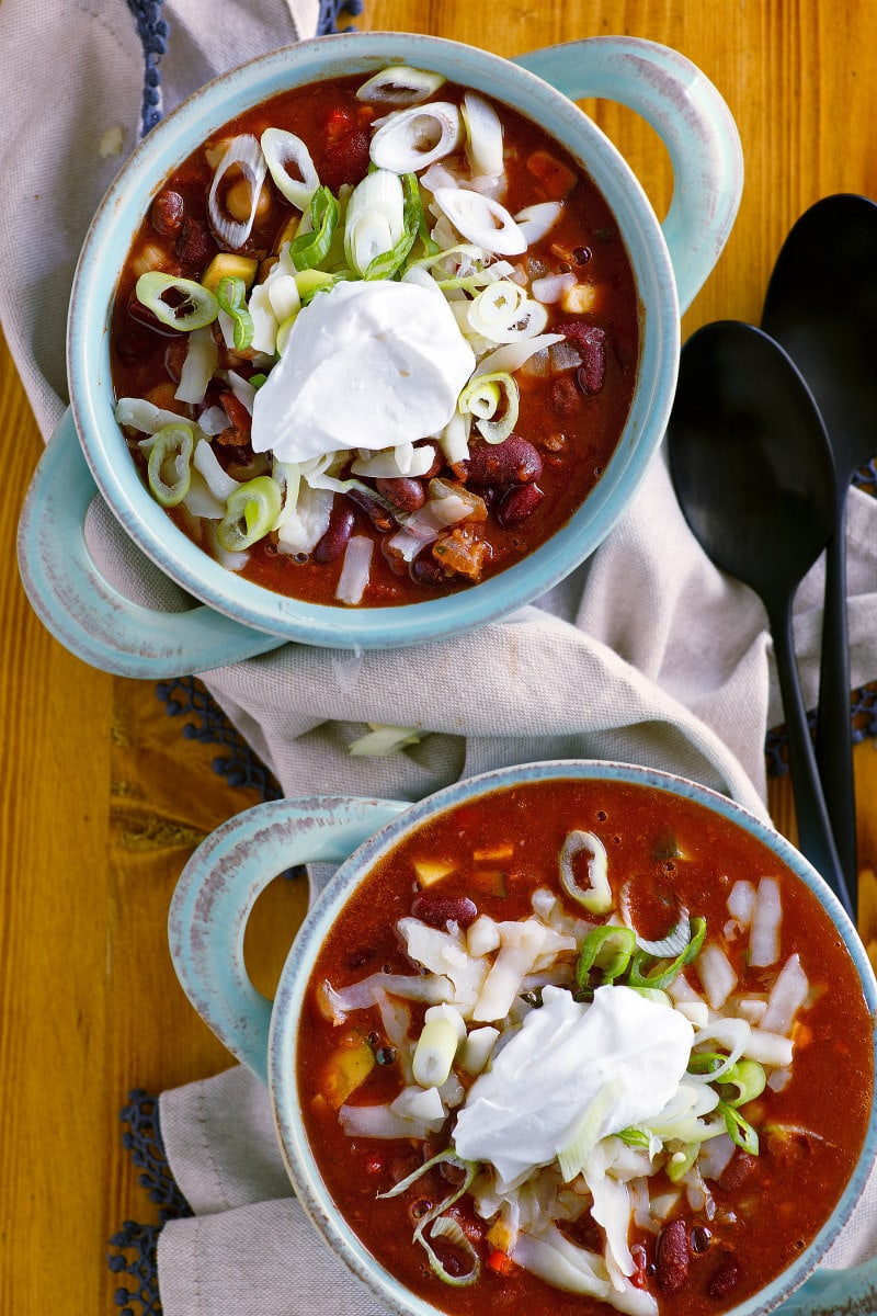 bowls of vegetarian chili with sour cream and cheese
