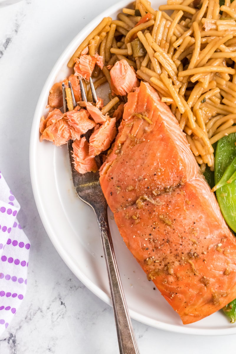 fork flaking away salmon on a plate