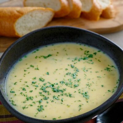 brown bowl of beer cheese soup with bread