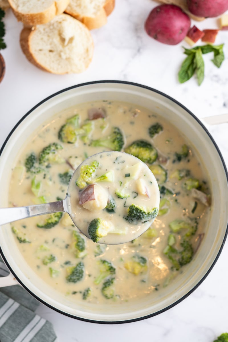 ladling broccoli potato soup out of pan