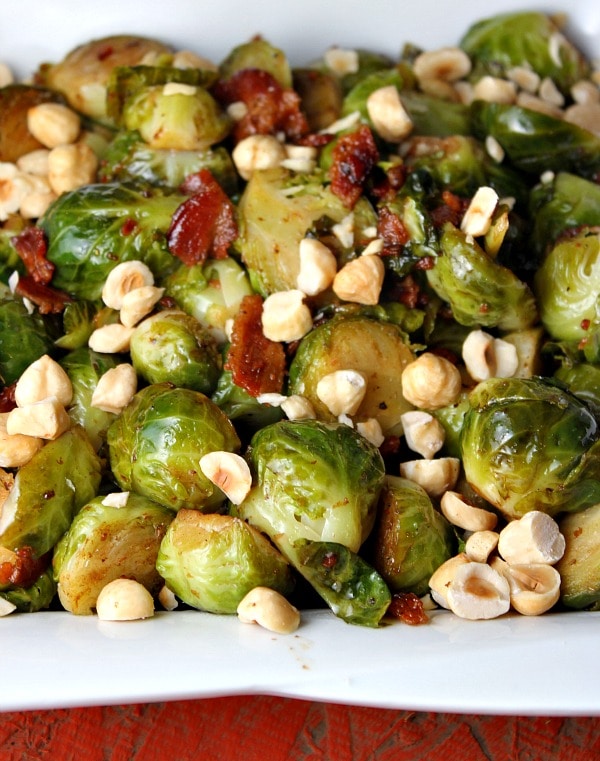 Brussels Sprouts with Bacon and Hazelnuts in a white dish