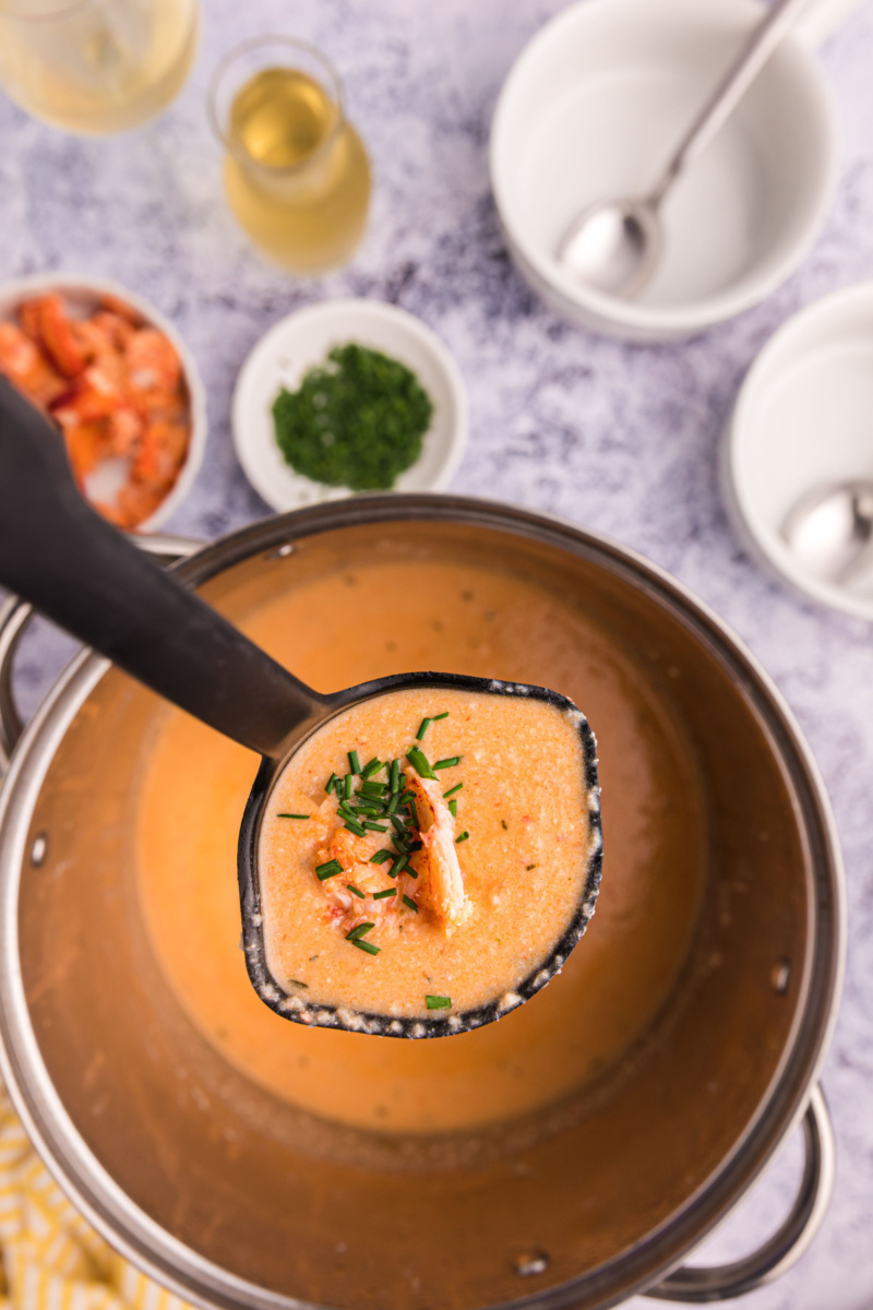 ladle of lobster bisque over pot