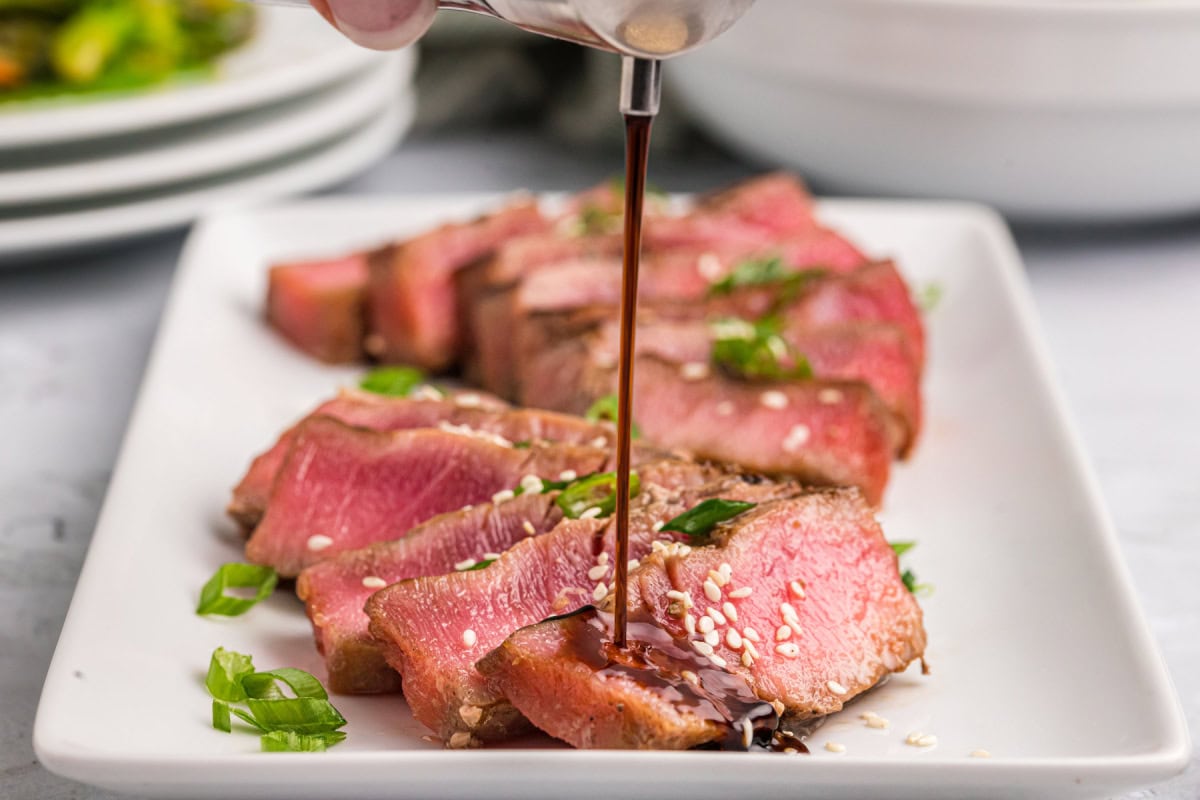 pouring sauce onto maple soy grilled tuna