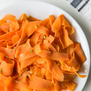 white plate of orange glazed carrot ribbons