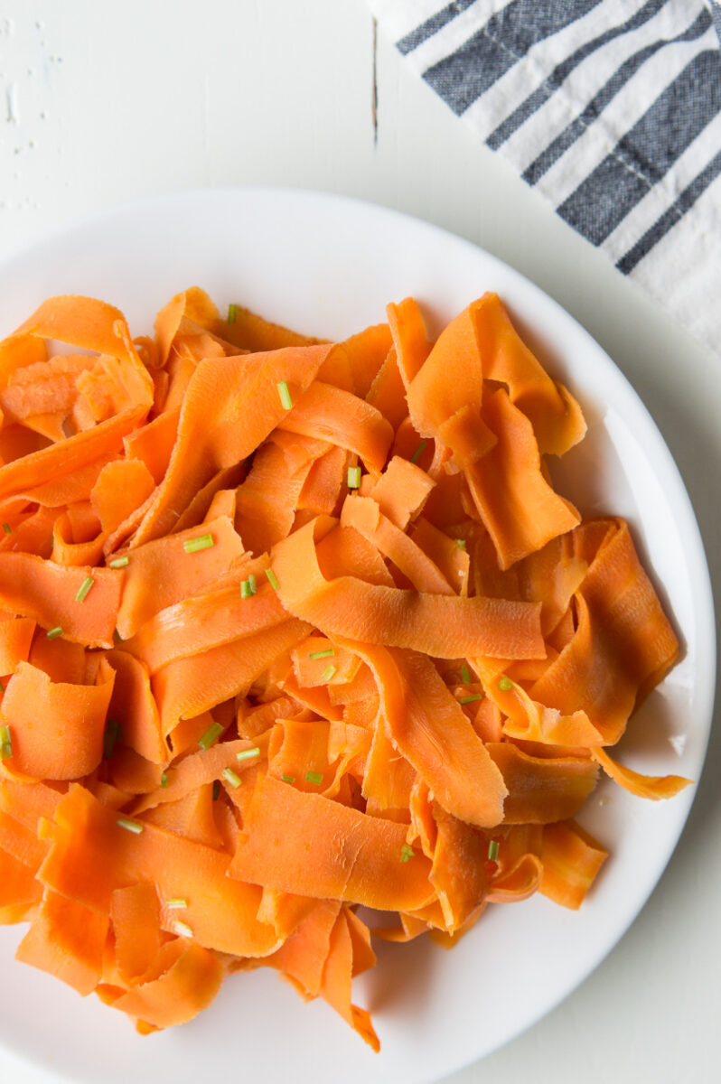 white plate of orange glazed carrot ribbons