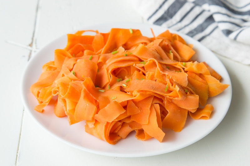 white plate of orange glazed carrot ribbons