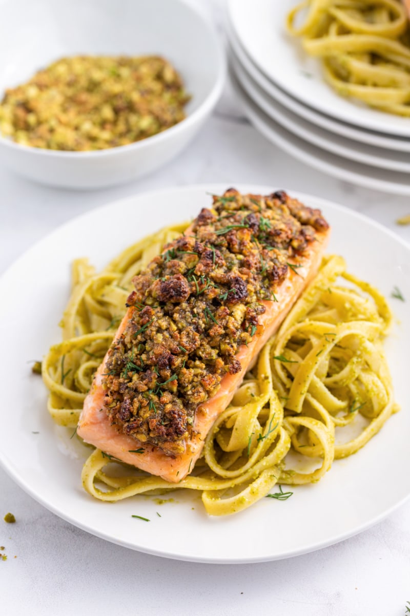 pistachio baked salmon on pasta on plate