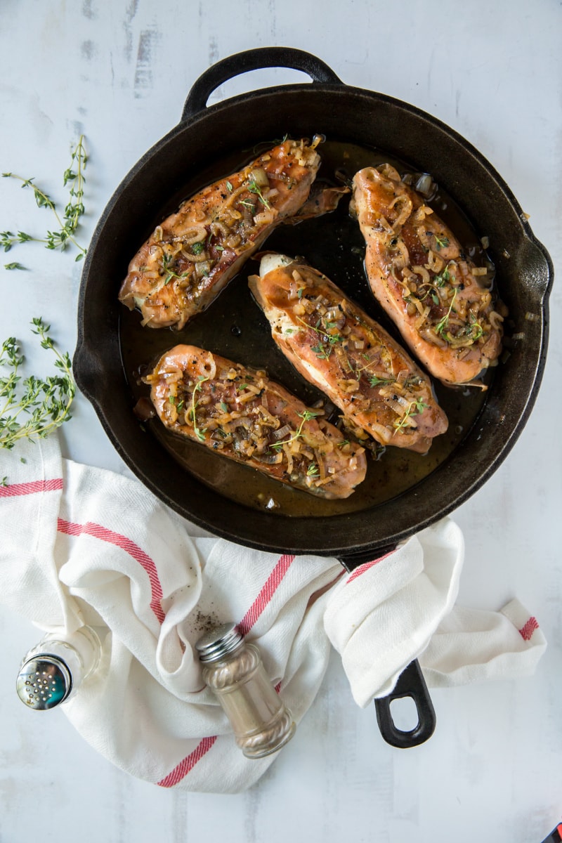 four prosciutto roasted halibut cooking in black skillet