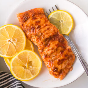 salmon fillet on plate with lemon slices