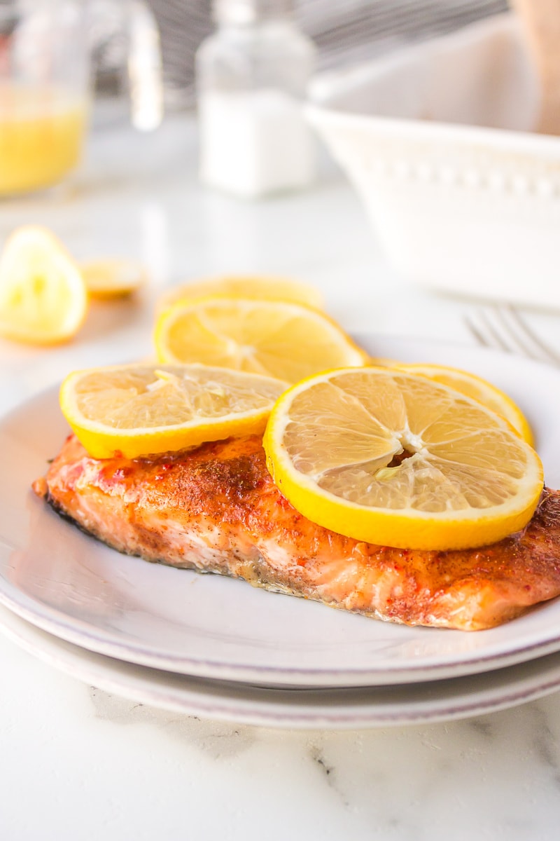 salmon fillet on plate topped with lemon slices