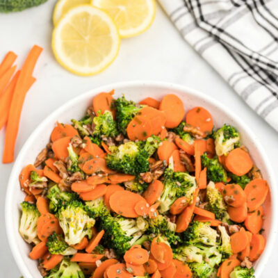 bowl of sauteed broccoli with carrots and pecans