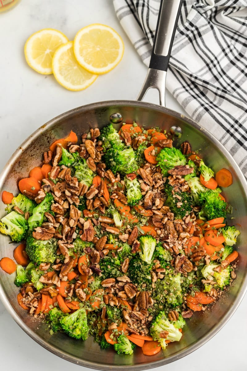 pan of sauteed broccoli with carrots and pecans