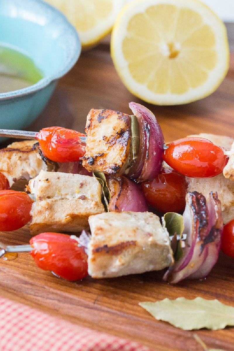 swordfish kebabs on a board with lemon