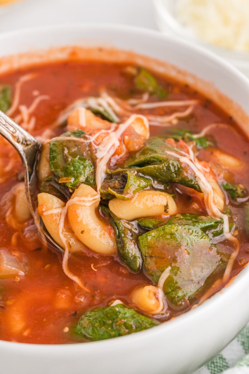 spooning out tomato florentine soup out of bowl