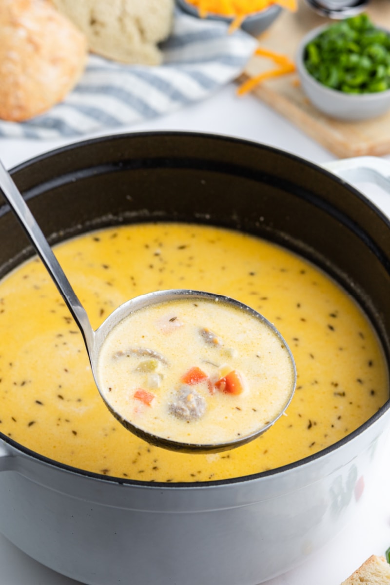 ladling out beer cheese soup out of pot