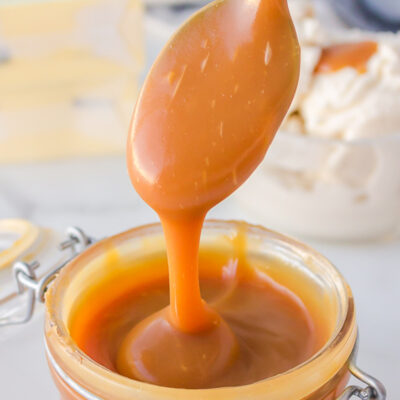 spooning caramel sauce out of jar