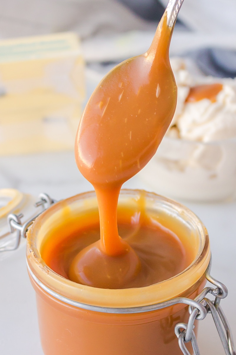 spooning caramel sauce out of jar