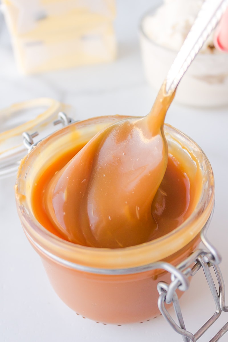 spooning caramel sauce out of jar