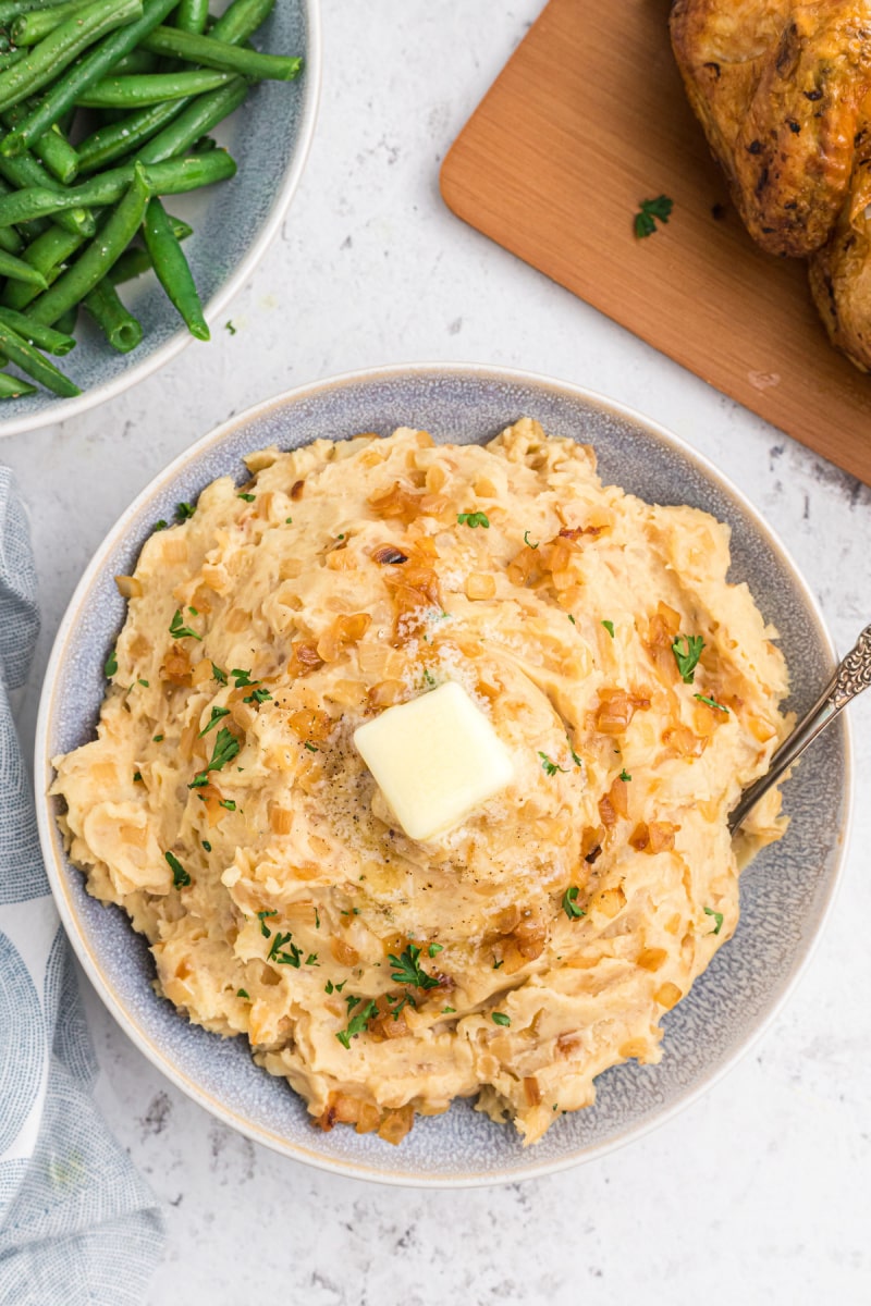 caramelized onion and horseradish mashed potatoes in a bowl with a pat of butter