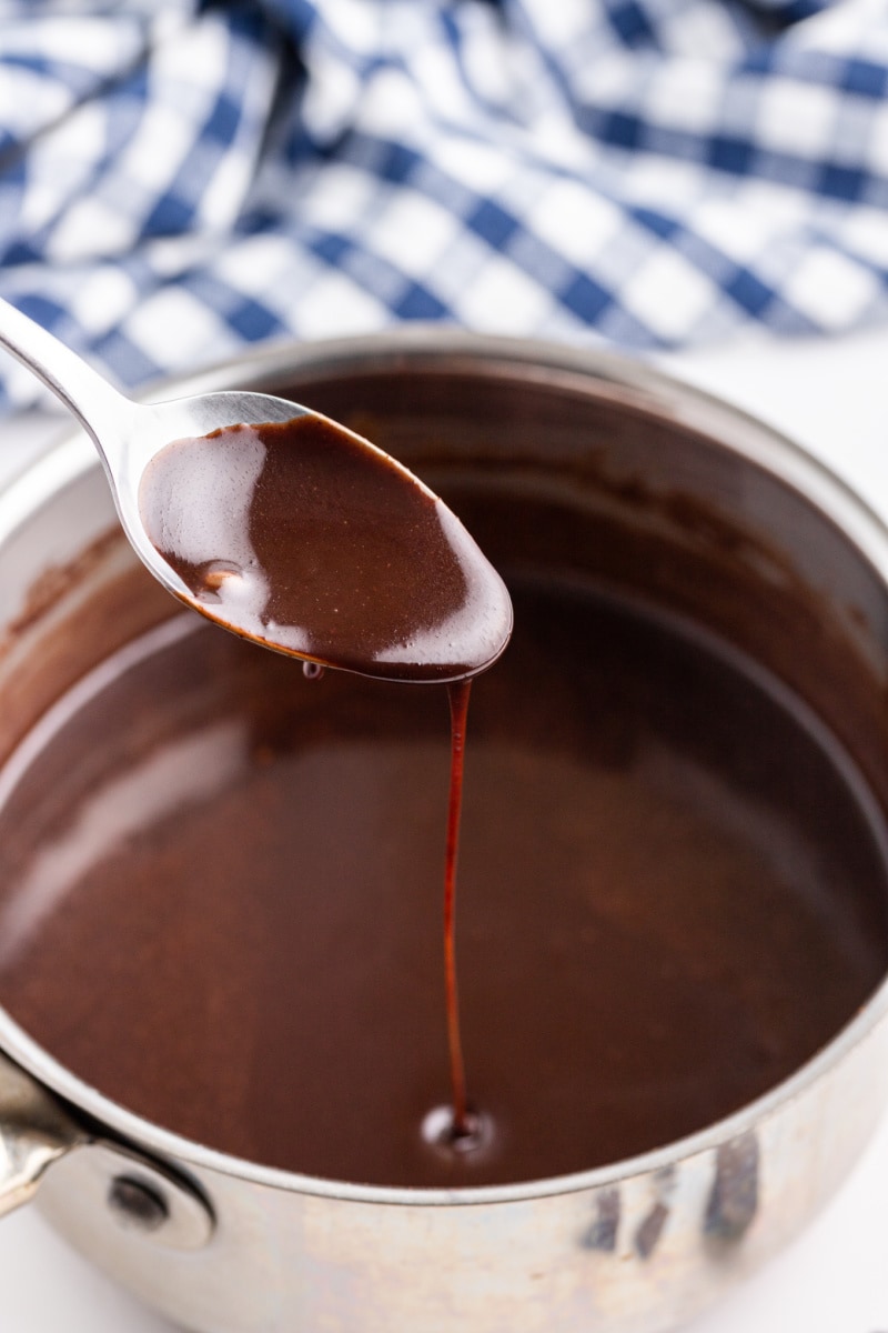 spooning out chocolate sauce out of pan