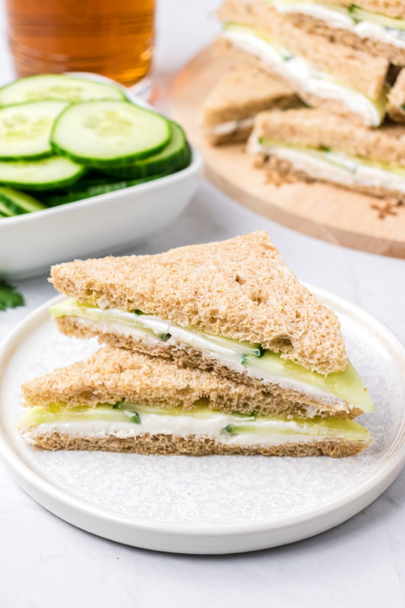 two goat cheese finger sandwich halves stacked on white plate