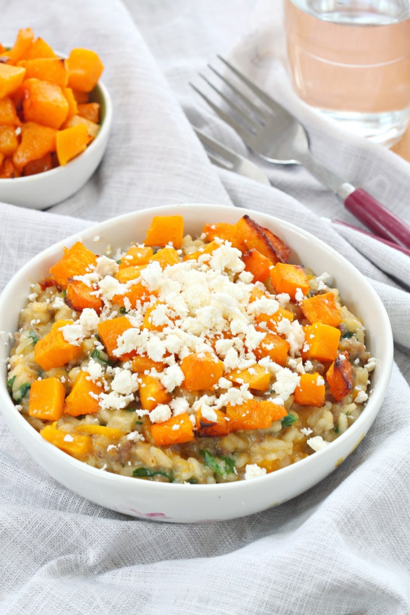 roasted pumpkin and sausage risotto in a white bowl