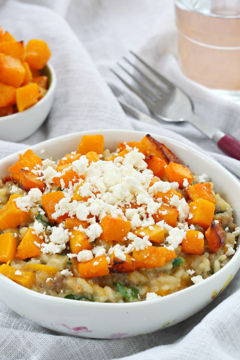 roasted pumpkin and sausage risotto in a white bowl