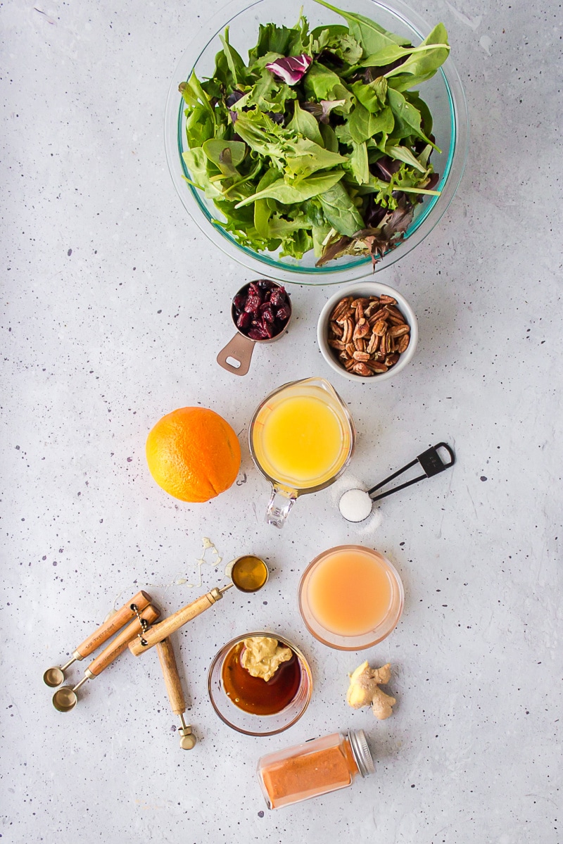 ingredients displayed for making salad with citrus vinaigrette and sugared pecans