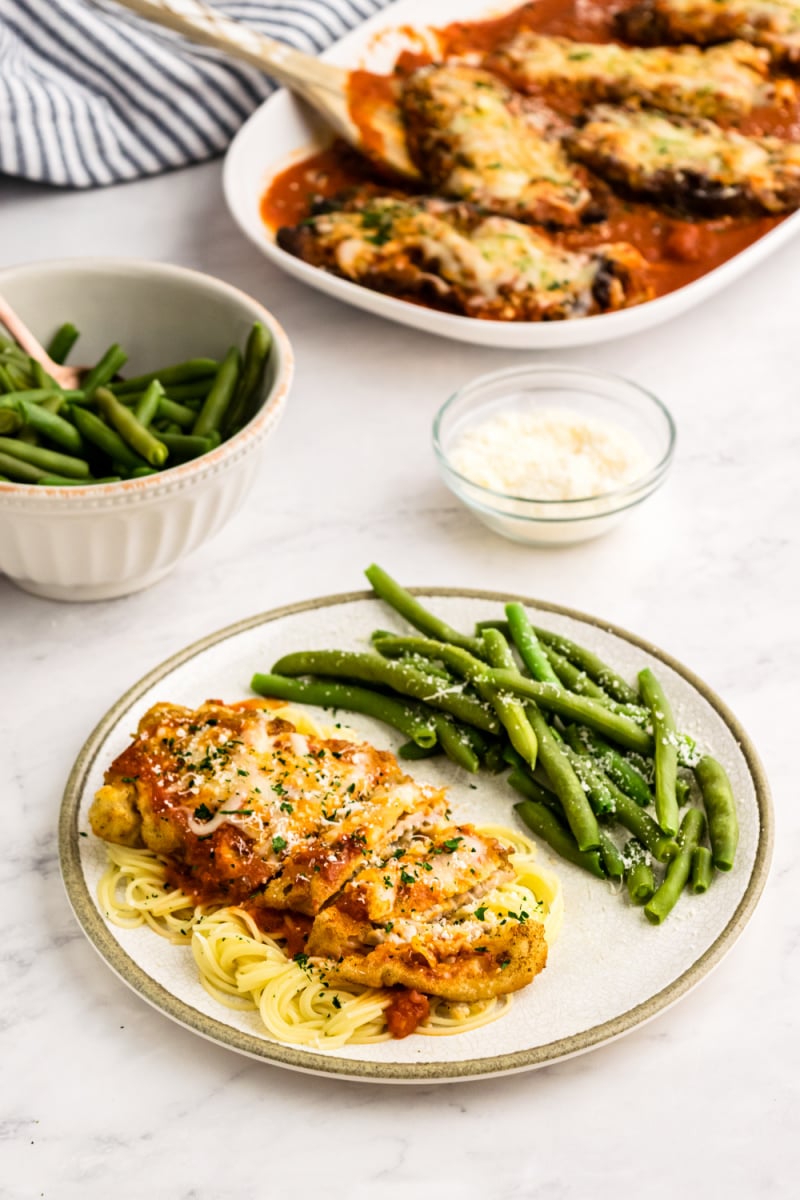 veal parmesan on a plate with green beans