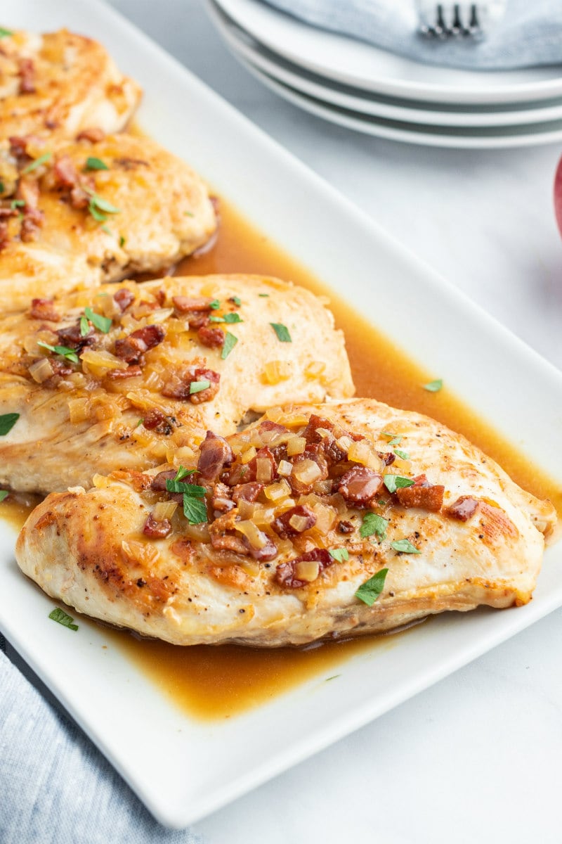 chicken with cider and bacon sauce on white platter