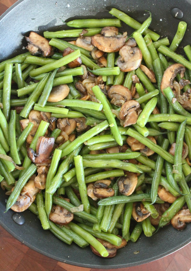 cooking Green Beans with Mushrooms and Shallots in a skillet