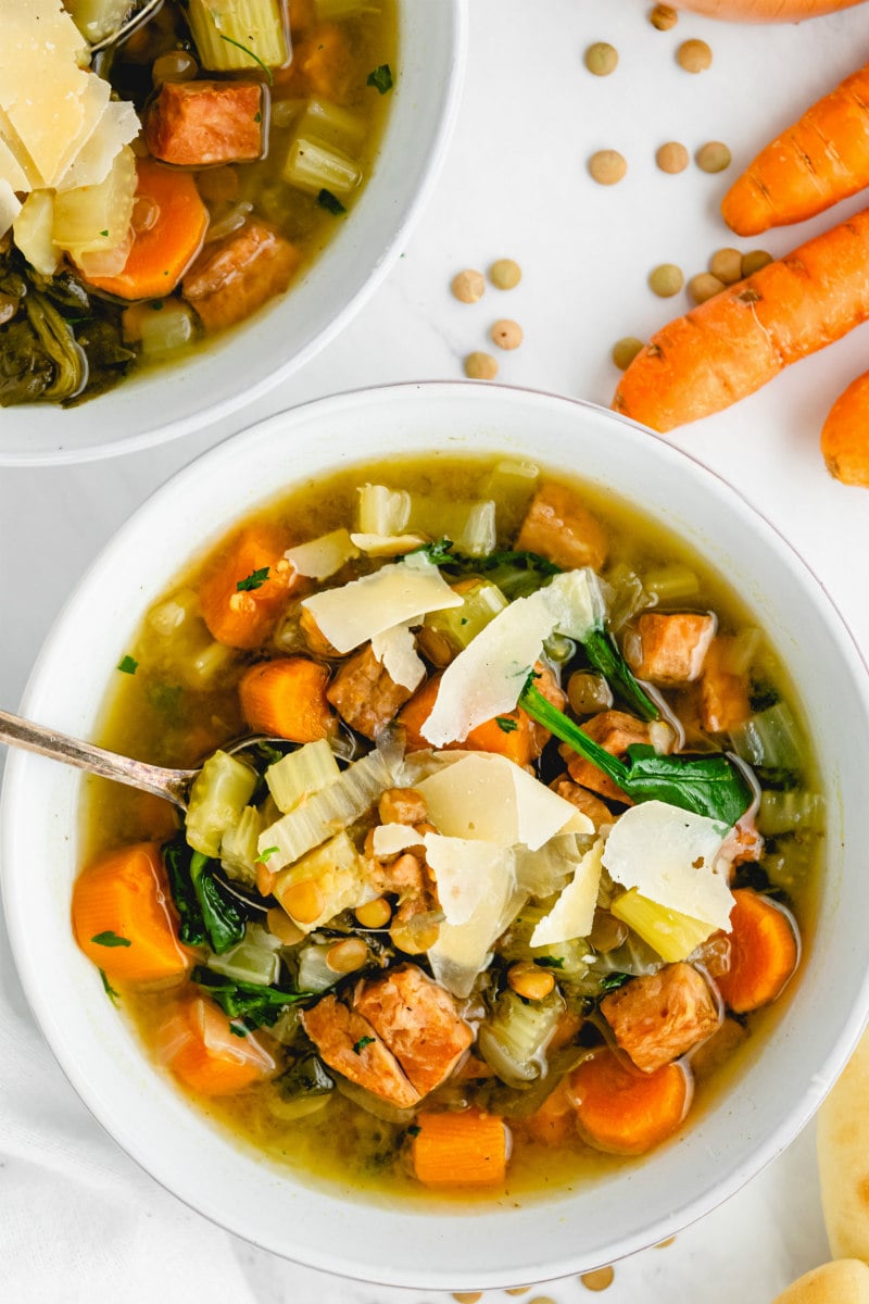 overhead shot of ham and lentil soup in white bowl