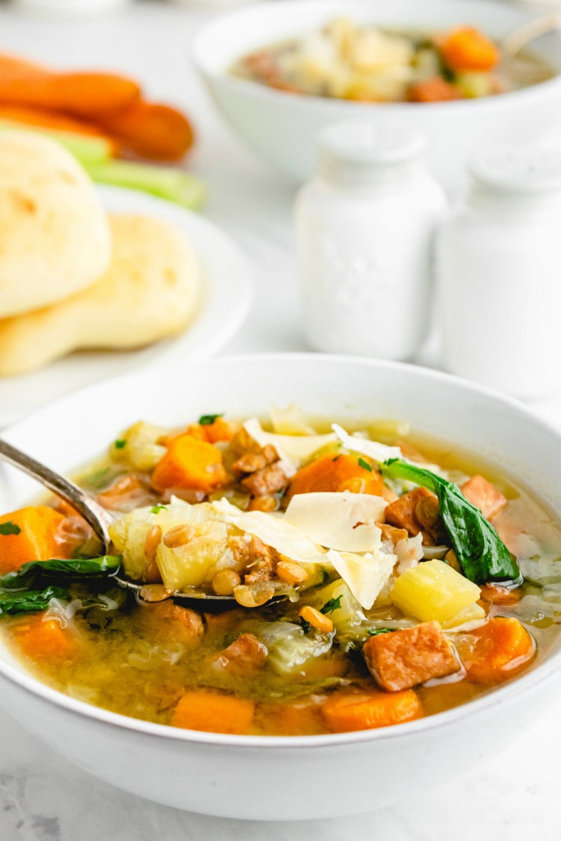 spoon in ham and lentil soup bowl