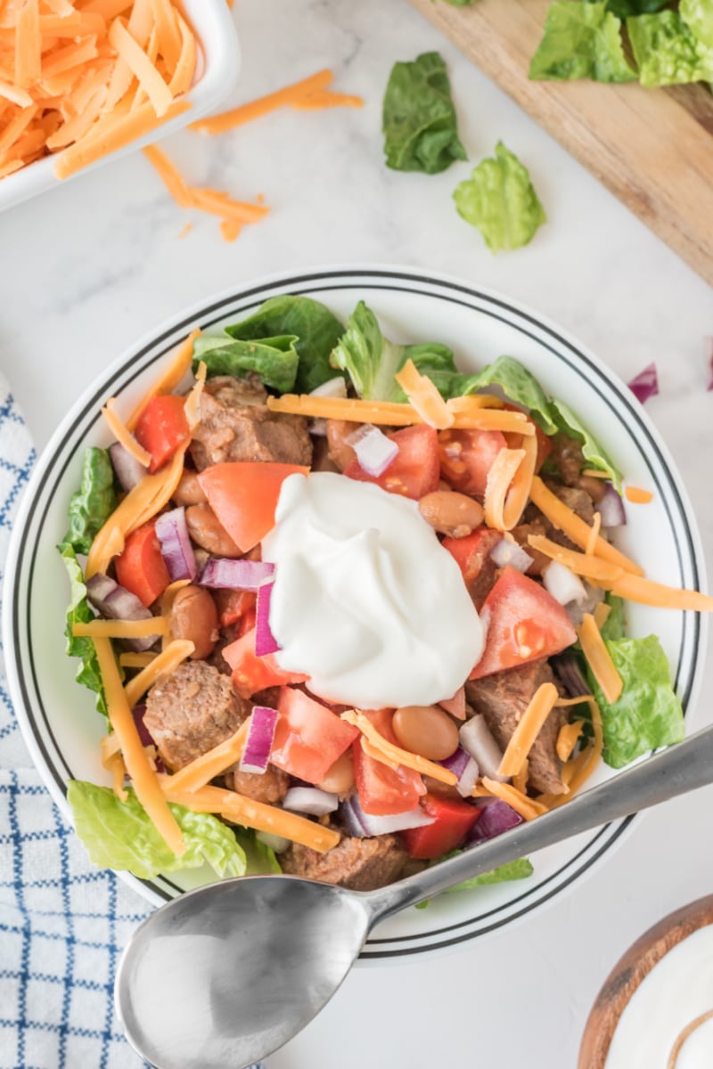 bowl of kick off chili with fixings on top