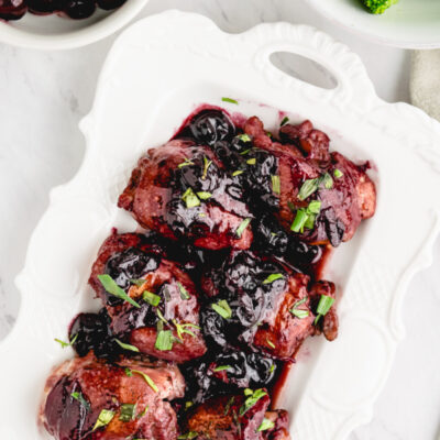 sauteed chicken with cherries in a white dish