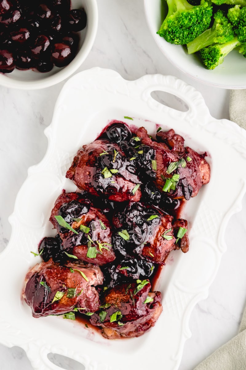 sauteed chicken with cherries in a white dish