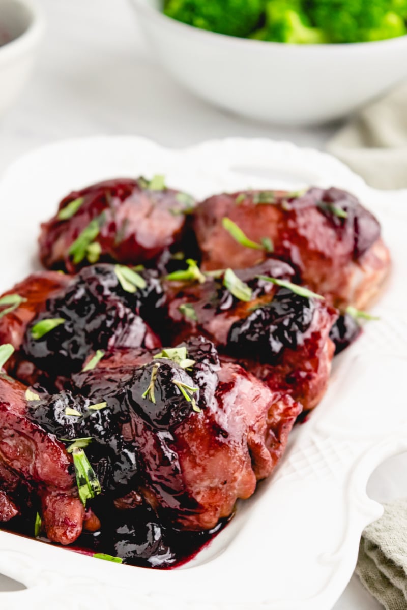 chicken with cherries in a white dish